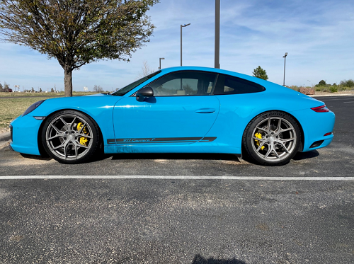 Blue 2019 Carrera sports car with Vossen wheels parked on the road
